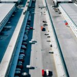 Aerial view of trucks outside giant logistics warehouse transit centre.