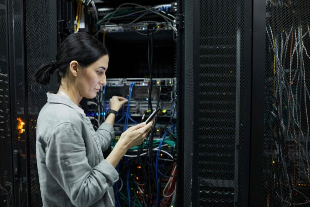 IT professional using a mobile device while working with network equipment in a server room.