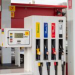 Close-up of fuel pumps at a service station, showing unleaded, premium unleaded and diesel nozzles alongside a digital fuel price display, illustrating fuel retail and energy infrastructure.