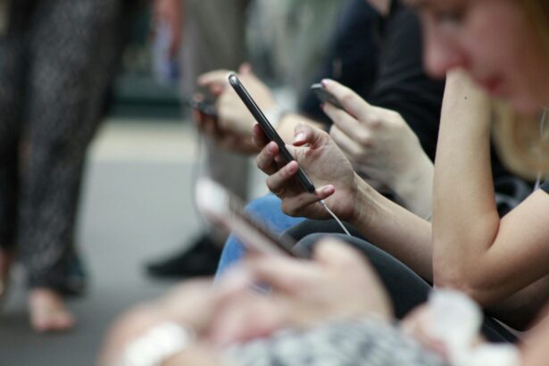 Close-up of people sitting side by side using smartphones, with multiple hands holding mobile devices, illustrating social media and digital connectivity.