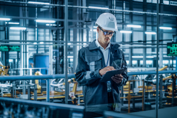 A man uses handheld device while standing in a warehouse environment.