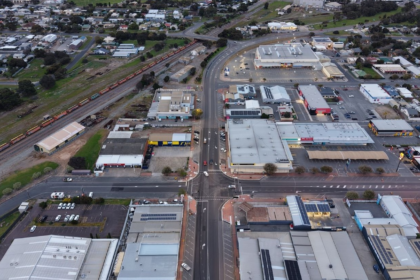 Aerial view of Port Lincoln showing roads, commercial buildings, residential areas and a freight rail line running through the town.
