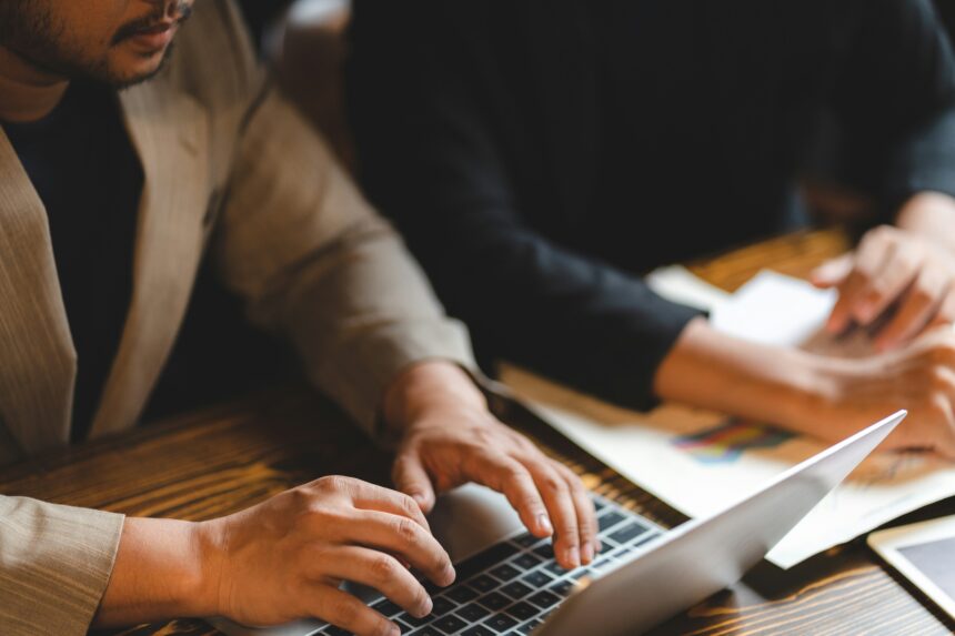 A businessman types on a laptop at office.