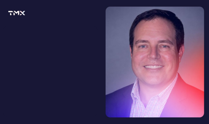 Professional headshot of a smiling man wearing a dark blazer and checked shirt, featured in a TMX-branded graphic with a navy background and pink and purple gradient.
