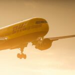 DHL plane flying at sunset mid air.