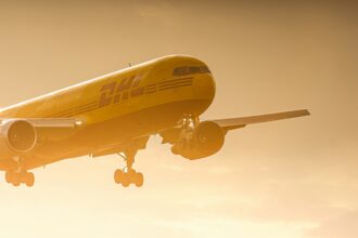 DHL plane flying at sunset mid air.