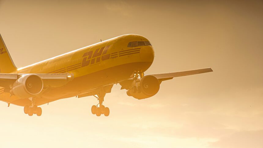 DHL plane flying at sunset mid air.
