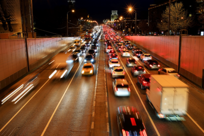 A busy highway road at night with orange hues.
